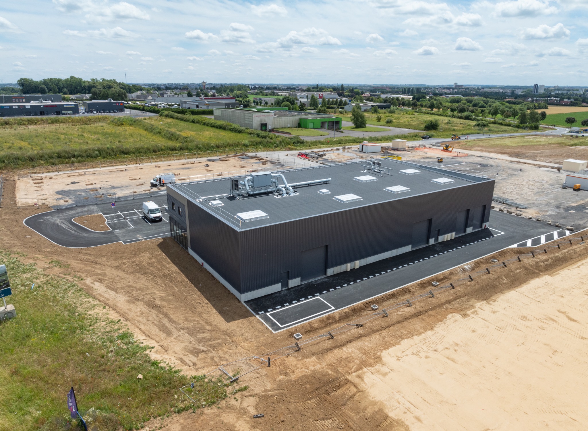 Vue aérienne détaillée d’un bâtiment récent, de ses accès et de ses aménagements